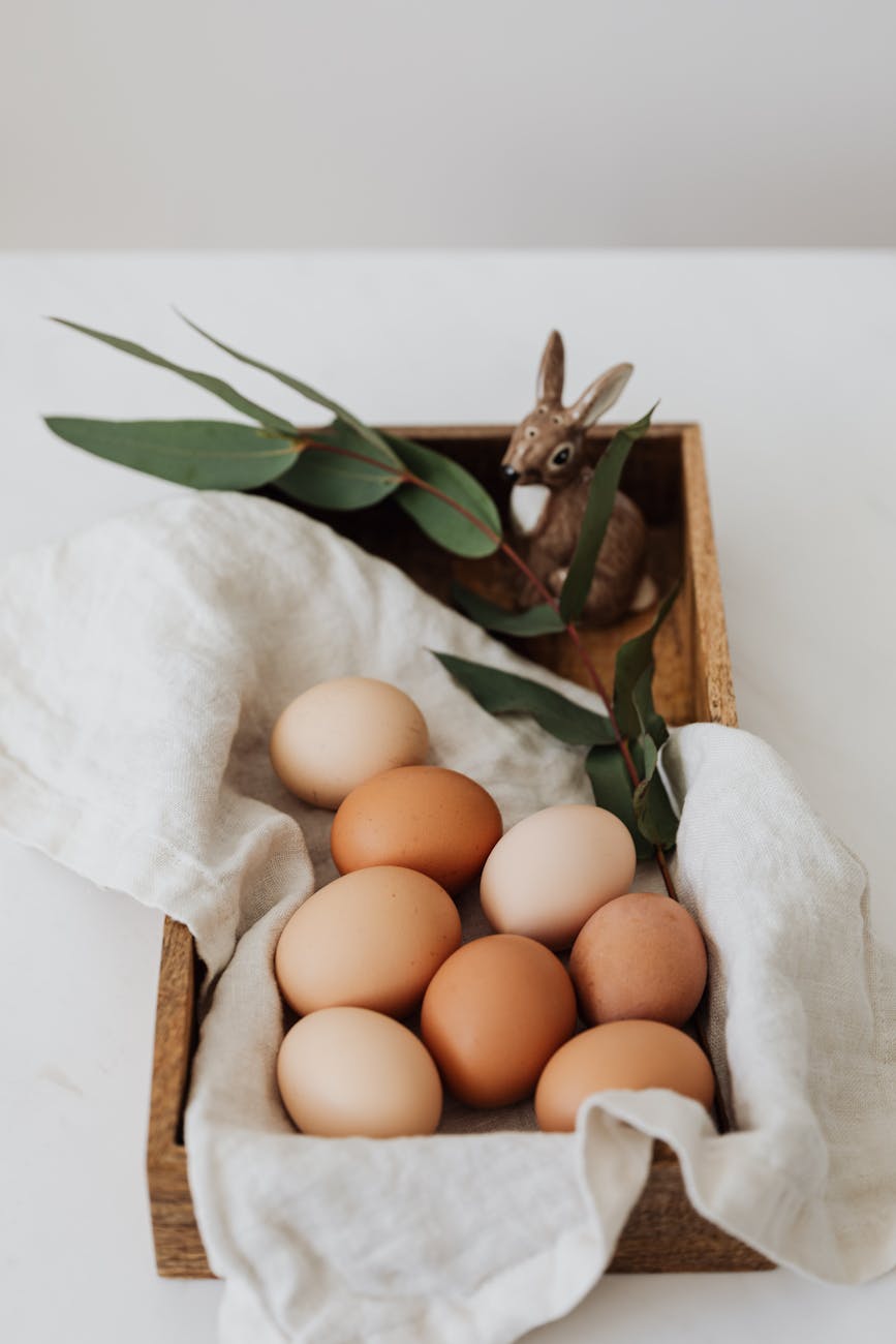 brown eggs and ceramic bunny on a wooden tray